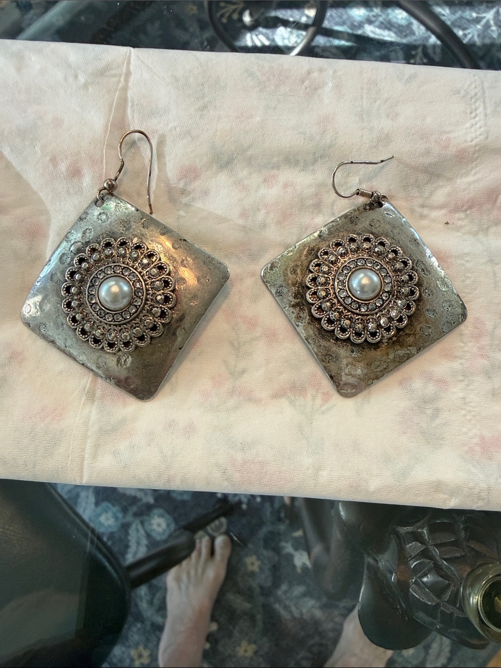 Silver triangle earrings with a pearl center.